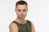 portrait of Zackery looking straight at the camera and wearing a sleeveless green shirt